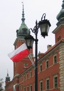 Polish Flag waving over Warsaw Royal Castle in the background